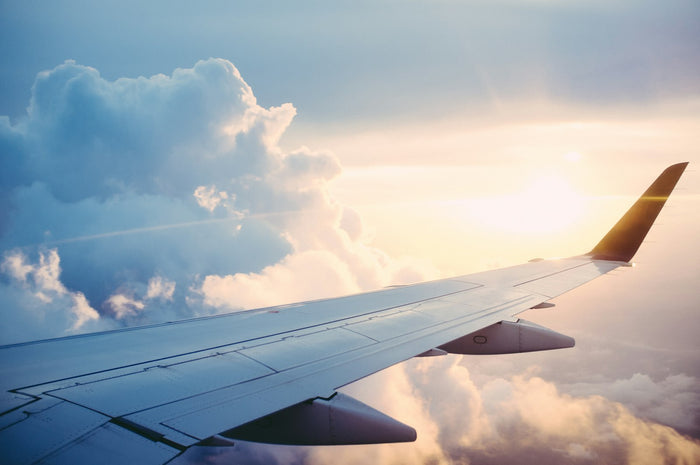 An aircraft wing above the clouds, seen from a window seat