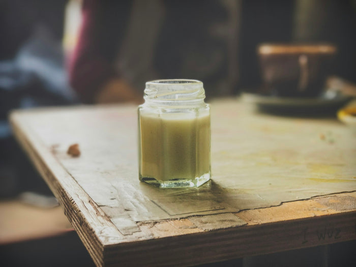 A small jar of ghee on a worn wooden bench