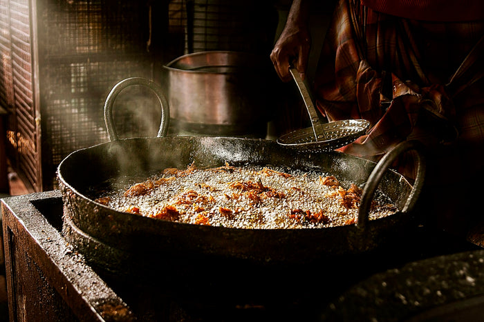 A cook frying in a wok over high heat