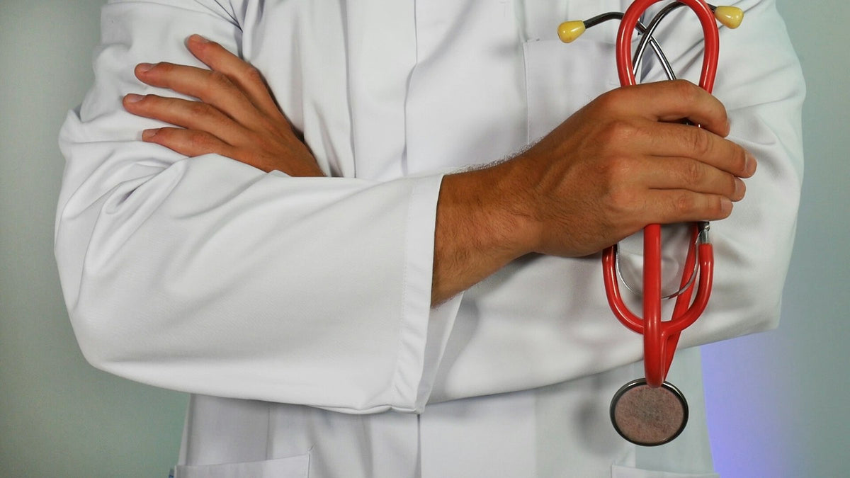 A doctor in a white coat holding a stethoscope