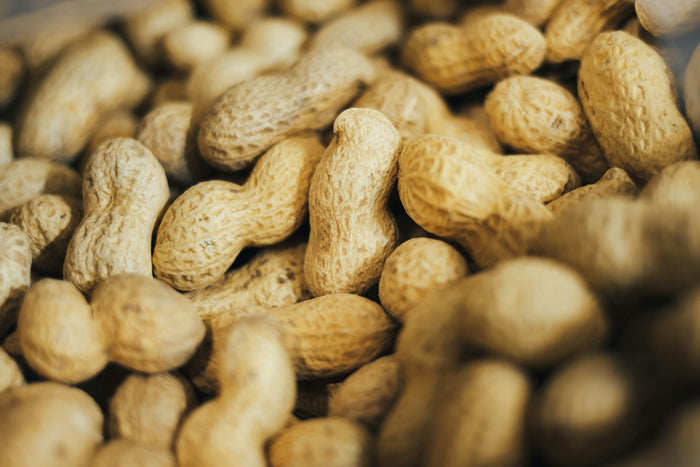 A close-up of a heap of peanuts in their shells