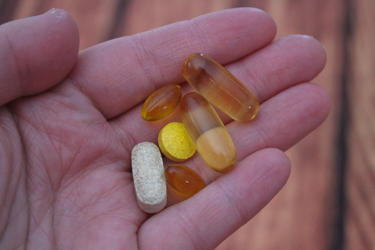 A hand holding assorted capsules