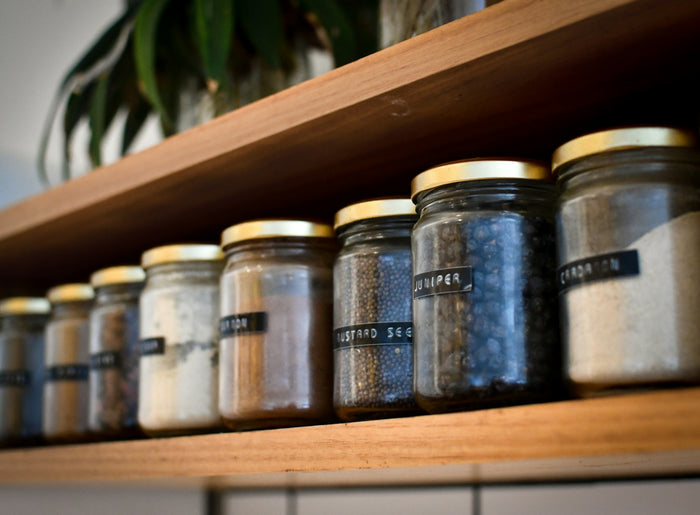 Rows of labelled glass jars on a kitchen shelf