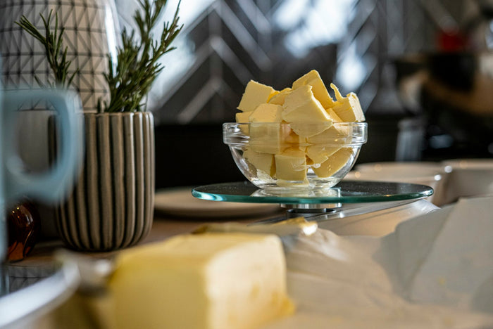 Cubes of butter in a glass dish beside a block of butter