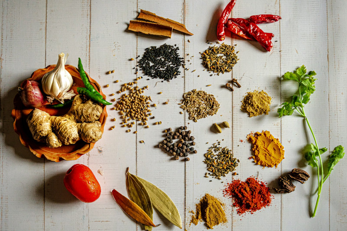 Whole spices, garlic and chillies laid out on a white board