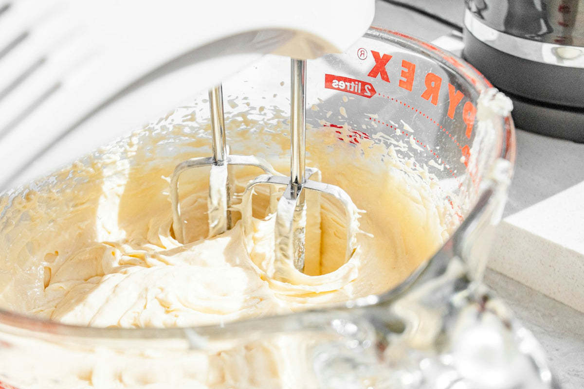 Cake batter in a mixing jug with beaters