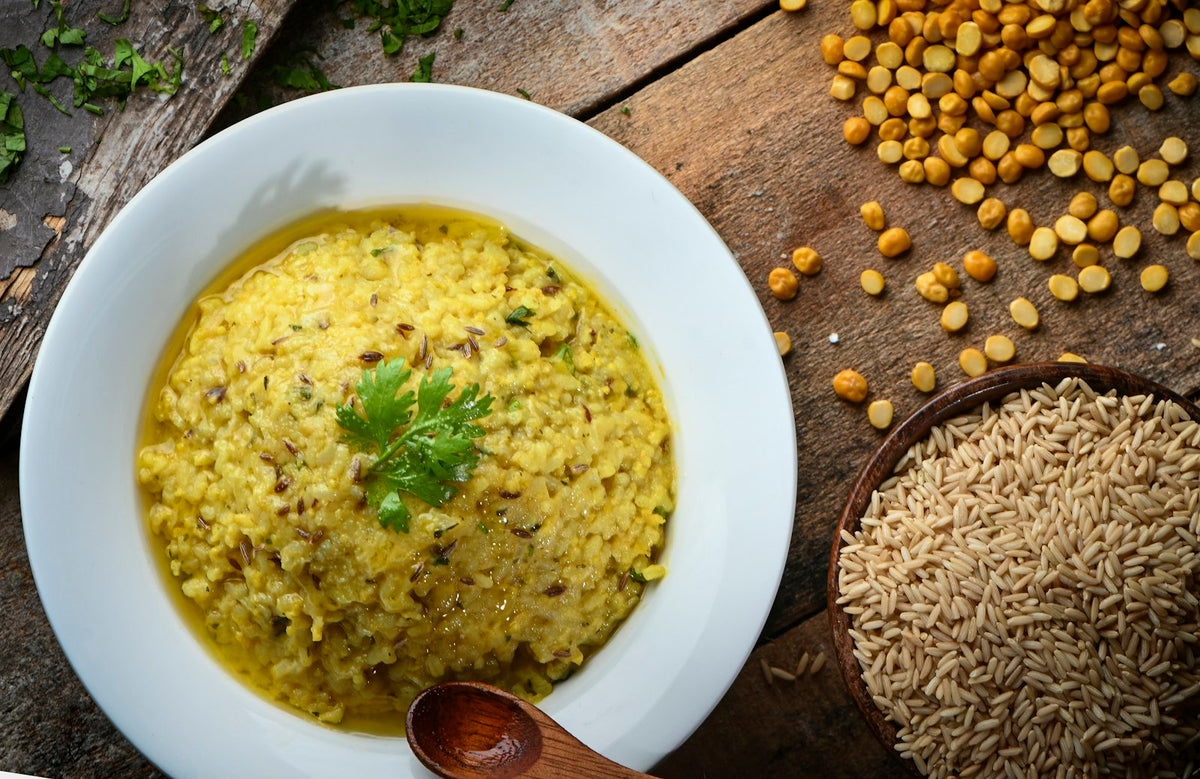 A bowl of khichdi with lentils and cumin alongside