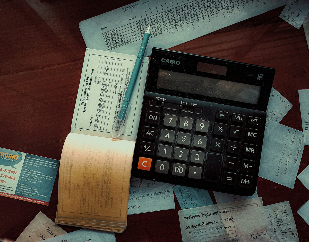 A calculator resting on a pile of invoices