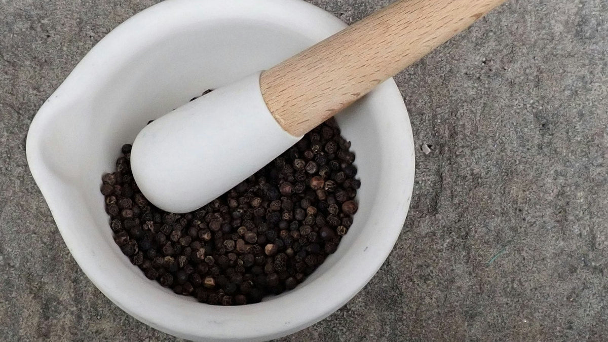 Peppercorns in a mortar with a pestle