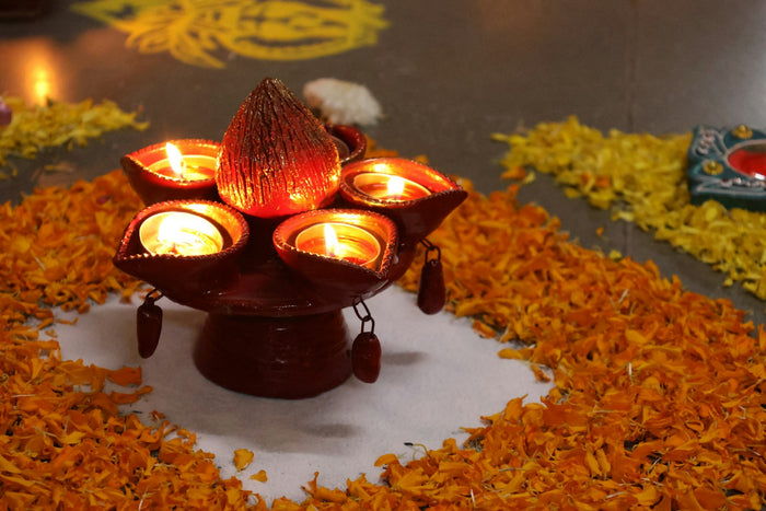 A brass lamp on a marigold rangoli