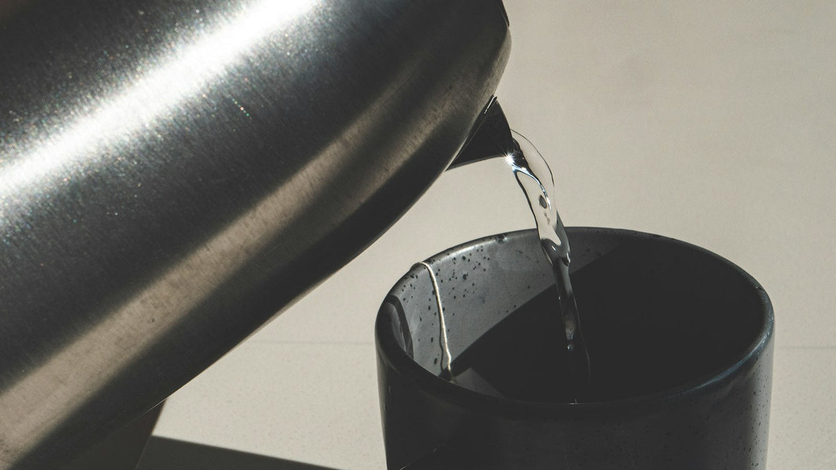 Hot water being poured from a kettle into a cup