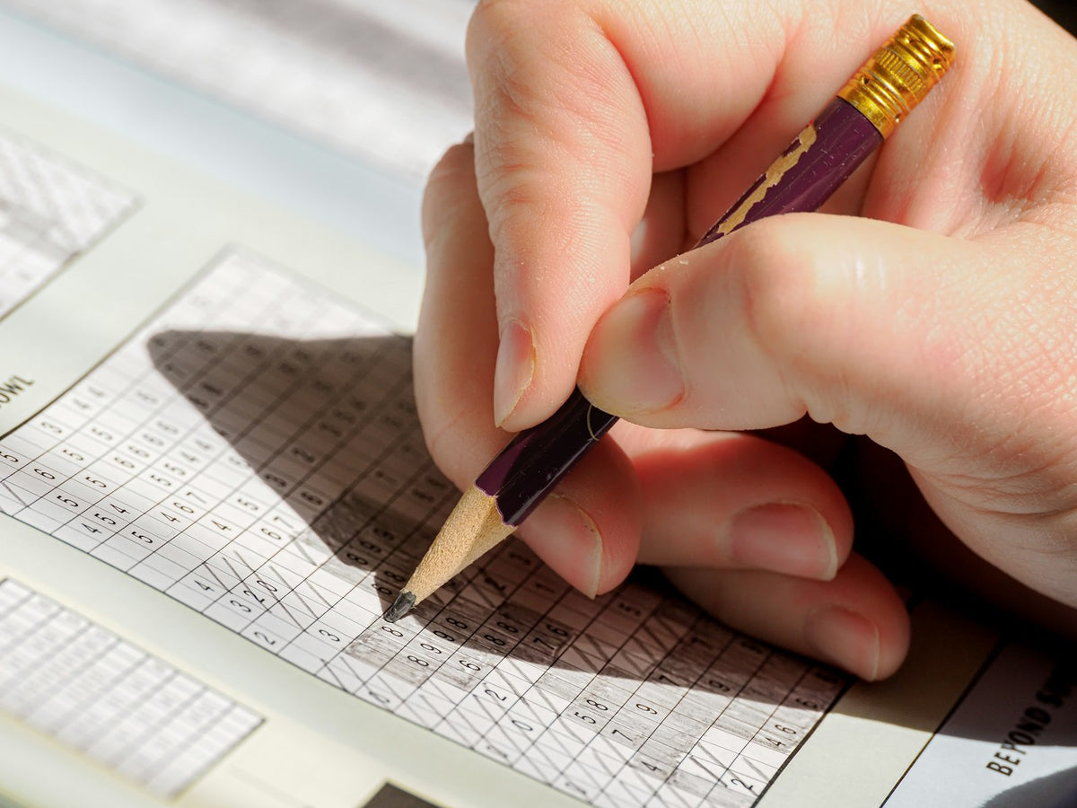 A hand writing figures in a ledger