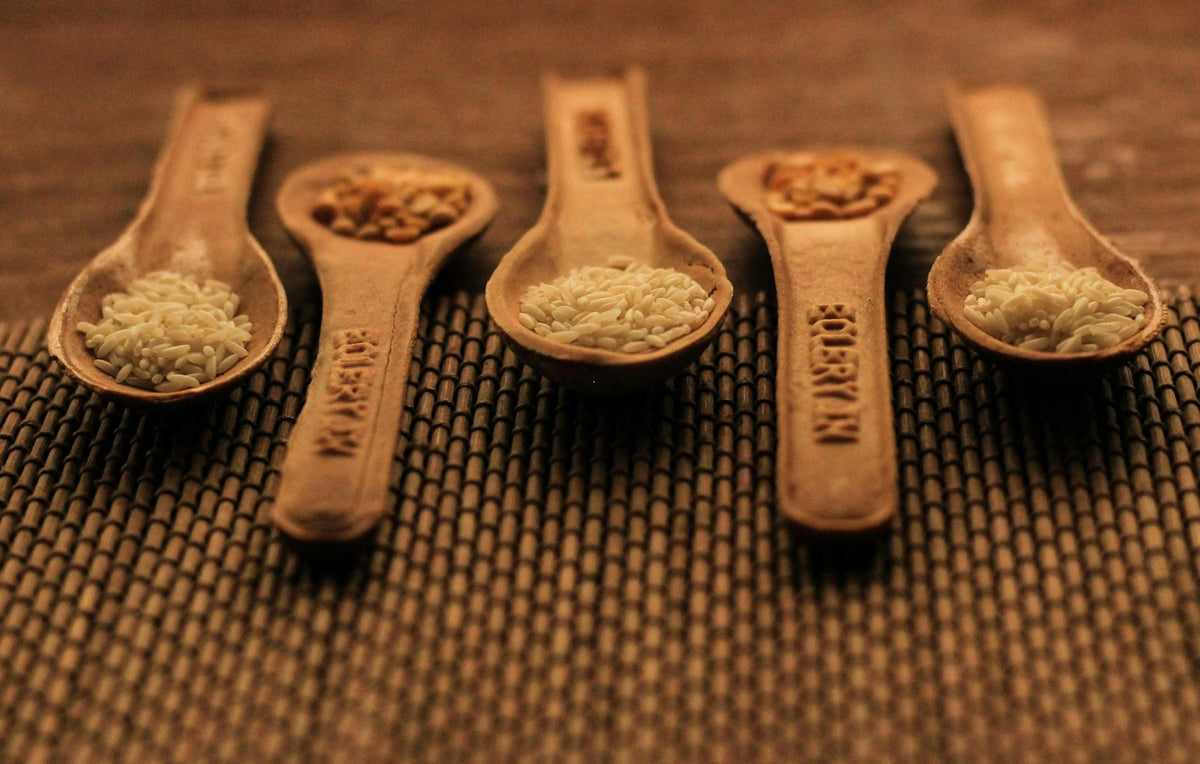 Wooden measuring spoons holding grains and seeds