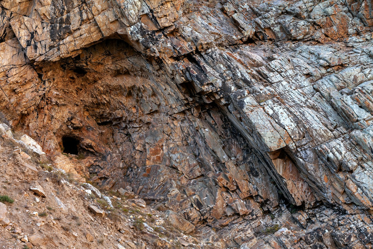 A layered brown rock face in the mountains