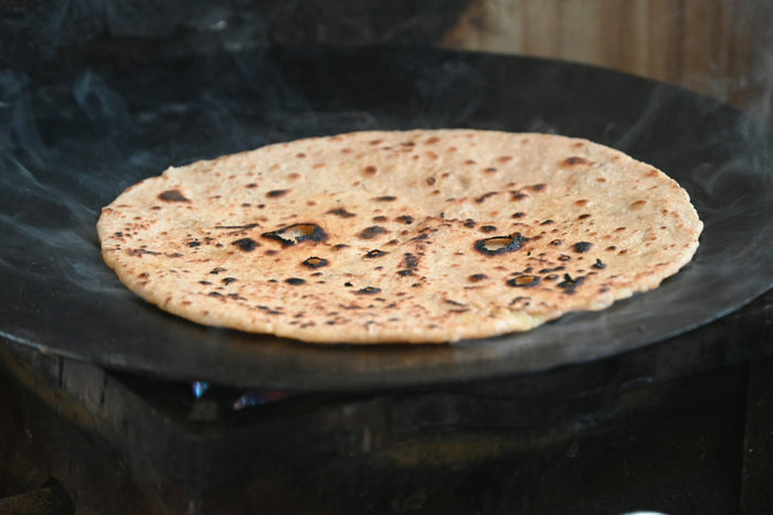 A chapati cooking on a tawa