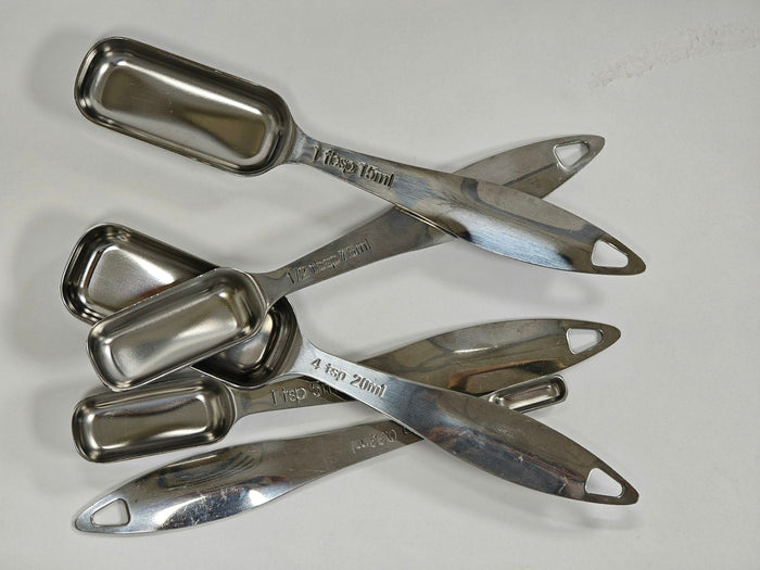 A set of steel measuring spoons