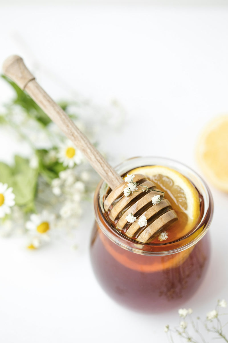 Honey being strained through a coarse mesh